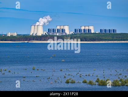 Cottbus, Deutschland. April 2024. Das Braunkohlekraftwerk Jänschwalde ist hinter dem Cottbus Ostsee zu sehen, der im ehemaligen Braunkohlebergwerk Cottbus-Nord entsteht. Der 19 Quadratkilometer große See soll zum größten künstlichen Gewässer Deutschlands werden. Die Überschwemmungen begannen Mitte April 2019 im ehemaligen Tagebau Cottbus-Nord. Die Lausitz Energie Bergbau AG (Leag) lässt Wasser von der Spree über den Hammergraben in das Tagebauloch für die Überschwemmung fließen. Quelle: Patrick Pleul/dpa/Alamy Live News Stockfoto