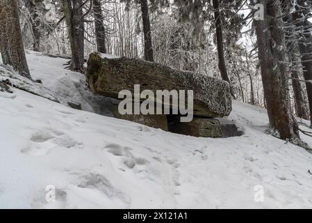 Geheimnisvolle Felsformation Certuv stul mit Bäumen um Certuv herum mlyn Hügel Gipfel im Winter Moravskoslezske Beskydy Berge in der Tschechischen republik Stockfoto