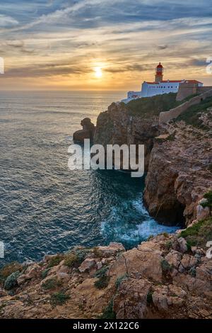 moody Blick auf Cabo Sao Vicente mit seinem berühmten Leuchtturm bei Sonnenuntergang an der Nehrung von south.estern in Europa in der Nähe von Sagres, Algarve, Portugal Stockfoto