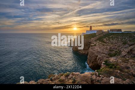 moody Blick auf Cabo Sao Vicente mit seinem berühmten Leuchtturm bei Sonnenuntergang an der Nehrung von south.estern in Europa in der Nähe von Sagres, Algarve, Portugal Stockfoto