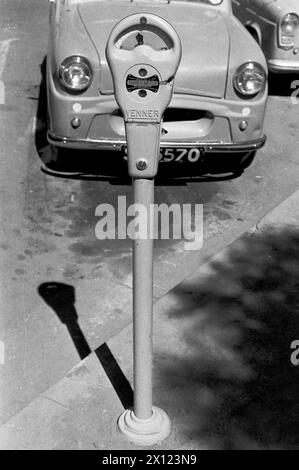 Early Venner Parking Meter oder Park-o-Meter and parked Vespa 400 (produziert 1957–1961) in der First Street Salisbury Rhodesia, heute Harare Simbabwe. Vintage Schwarzweiß- oder Schwarzweiß-Foto c1960. Stockfoto