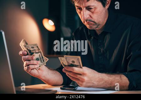 Geschäftsmann, der amerikanische Dollar am Schreibtisch zählt, selektiver Fokus Stockfoto