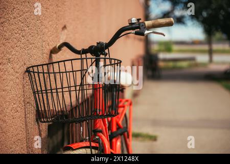 Rotes Vintage-Fahrrad auf der Straße, an der Gebäudewand angelehnt, selektiver Fokus Stockfoto