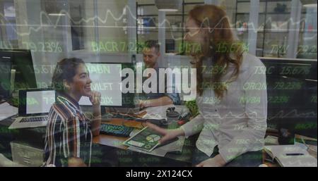 Drei Geschäftsfrauen, eine kaukasierin und zwei Birassisten, arbeiten in einem modernen Büro zusammen Stockfoto