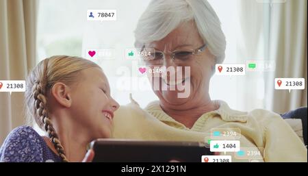 Bild von den Benachrichtigungsbalken über kaukasische Großmutter und Enkelin mit einem digitalen Tablet Stockfoto