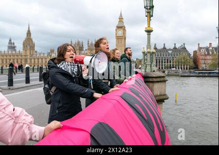 London, Großbritannien. 15. April 2024. Klimaaktivisten von Climate Resistance werfen ein Banner von der Westminster Bridge mit der Aufschrift „Stop Poluting Politics“. Anrede: Andrea Domeniconi/Alamy Live News Stockfoto