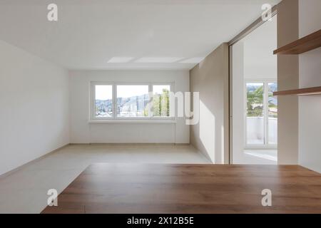 Blick auf ein leeres Esszimmer mit einem großen Fenster im Hintergrund. Moderne, stilisierte Innenarchitektur. Stockfoto