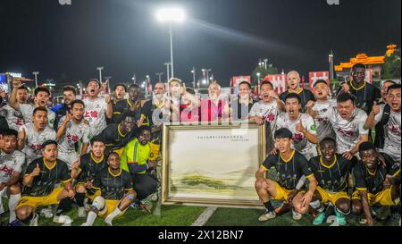 Peking, China. April 2024. Spieler des internationalen Studenten-Fußballteams der Universität Guizhou und des Fußballteams Jiangxi Rice Noodle posieren für Fotos nach einem Freundschaftsspiel im Bezirk Rongjiang im Südwesten Chinas in der Provinz Guizhou, 13. April 2024. Am Samstagabend ein auffälliges Fußballspiel wurde in der chinesischen „Village Super League“ im County Rongjiang eingeläutet. Das Fußballteam aus internationalen Studenten der Universität Guizhou spielte gegen das Jiangxi Rice Noodle Team aus Shangrao City. Quelle: Tao Liang/Xinhua/Alamy Live News Stockfoto