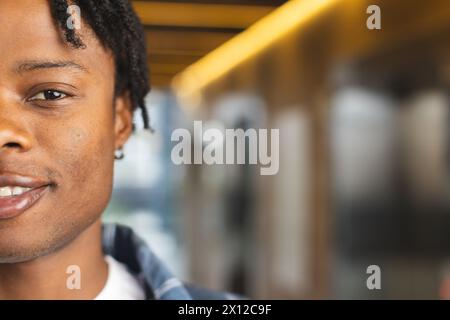 Afroamerikaner, der in einem modernen Geschäftsbüro steht, lässige Kleidung trägt, mit Kopierraum Stockfoto