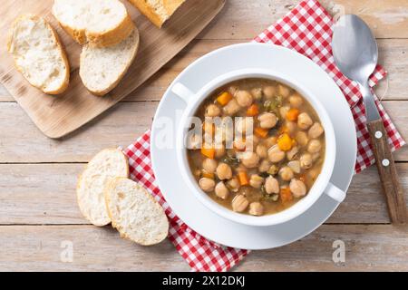 Kichererbsensuppe mit Gemüse in einer Schüssel auf Holztisch Stockfoto