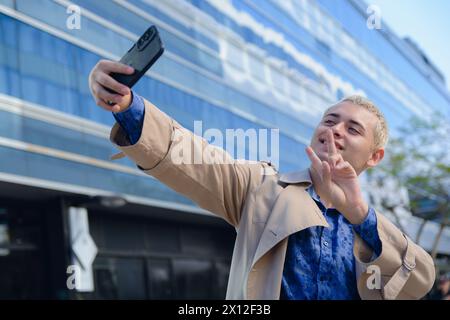 Junger lateinamerikanischer argentinischer Mann, hübscher blonder Unternehmer in formeller Kleidung, der im Freien Selfie-Foto mit seinem Handy macht Stockfoto