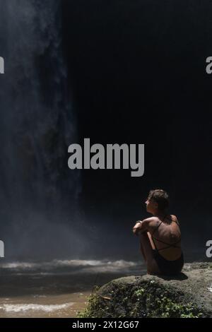 Eine Reisende Frau im Dschungel, die den Wasserfall Nung Nung ansieht. Bali Stockfoto