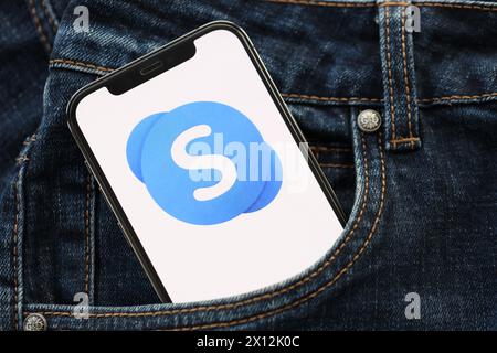 KIEW, UKRAINE – 1. APRIL 2024 Skype-Symbol auf dem Smartphone-Display in der Jeanstasche. IPhone-Display mit App-Logo in modischer Jeans-Tasche aus nächster Nähe Stockfoto