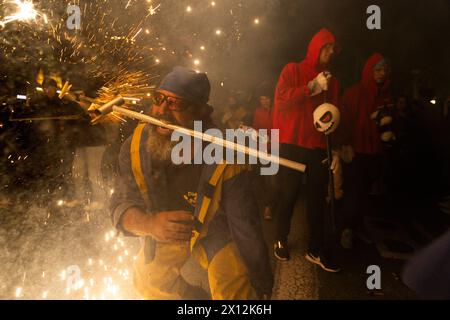 Ein Correfoc steckt ihm den Stock mit einem Feuerwerk in den Mund. Passeig de Gràcia - Barcelona - Spanien Stockfoto