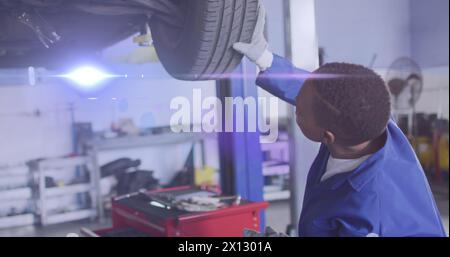 Lichtbild über dem afroamerikanischen männlichen Mechaniker-Reparaturwagen Stockfoto