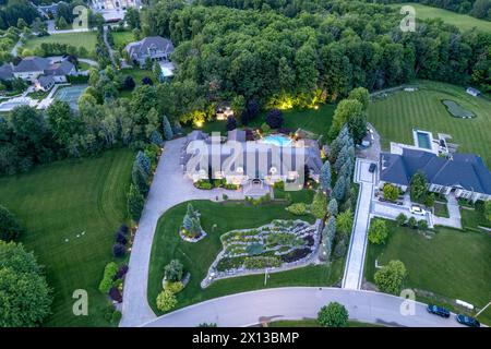 Erleben Sie den Reiz luxuriöser, Millionen-Dollar-Häuser in faszinierenden Landschaften der Dämmerung. Erkunden Sie atemberaubende Garten- und Hinterhofdesigns unter der Nacht Stockfoto