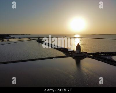 Aus der Vogelperspektive auf die Salinen von Stagnone und die alten Windmühlen bei Sonnenuntergang Stockfoto