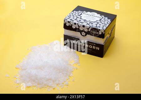 120 Gramm Blackthorn Scottish Sea Salt Flakes, die auf einem gelben Hintergrund verschüttet werden Stockfoto