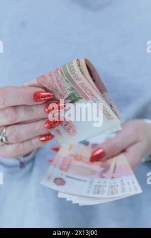 Weibliche Hände, die Papierscheine in russischen Rubel halten Stockfoto