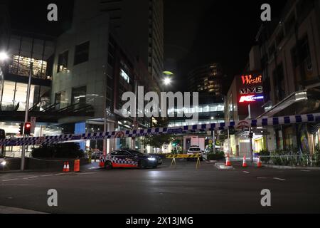 Sydney, Australien. April 2024. Der Tatort von Westfield Bondi Junction ist immer noch von der Polizei gesperrt und die Leute lassen Blumen im Einkaufszentrum gegenüber, nachdem ein geistig kranker Messerangreifer, der 40-jährige Joel Cauchi, einen Amoklauf begangen hat und 6 Menschen getötet hat. Fotos, die am Montag, 15. April gegen 21:00 Uhr aufgenommen wurden. Richard Milnes/Alamy Live News Stockfoto