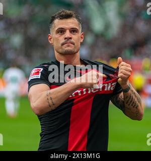 Leverkusen, Nordrhein-Westfalen, Deutschland. April 2024. Bayer-Leverkusen-Mittelfeldspieler GRANIT XHAKA (34) zeigt auf das Mannschaftswappen, nachdem er am 14. April 2024 im Spiel zwischen Bayer Leverkusen und Werder Bremen in der BayArena in Leverkusen (Nordrhein-Westfalen) ein Tor geschossen hat. Quelle: ZUMA Press, Inc./Alamy Live News Stockfoto