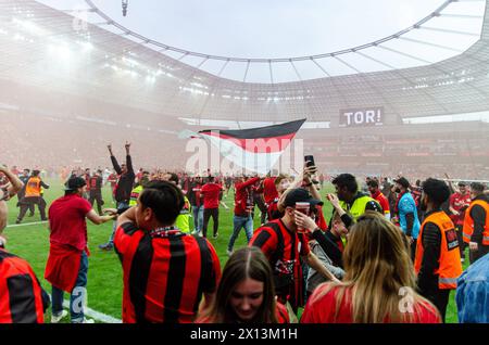 Leverkusen, Nordrhein-Westfalen, Deutschland. April 2024. Bayer-Leverkusen-Fans erobern das Spielfeld nach einem Tor im Spiel der Bundesliga 29 zwischen Bayer Leverkusen und Werder Bremen am 14. April 2024 in der BayArena in Leverkusen. Quelle: ZUMA Press, Inc./Alamy Live News Stockfoto