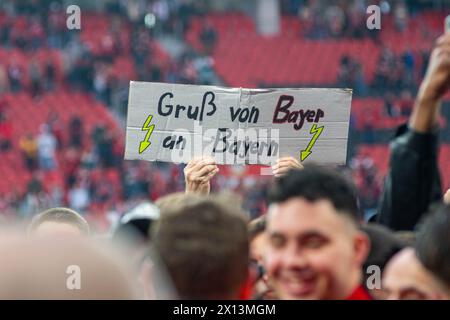 Leverkusen, Nordrhein-Westfalen, Deutschland. April 2024. Ein Fan trägt ein Schild mit der Aufschrift "Gruss von Bayer an Bayern". nach dem 29. Bundesliga-Spiel zwischen Bayer Leverkusen und Werder Bremen am 14. April 2024 in der BayArena in Leverkusen (Nordrhein-Westfalen) gewann Bayer Leverkusen den 2023-2024er Bundesliga-Titel. Quelle: ZUMA Press, Inc./Alamy Live News Stockfoto