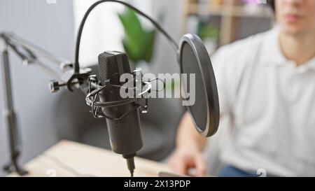 Junger Mann mit Mikrofon in einem Radiostudio, der sich auf eine Sendung vorbereitet Stockfoto