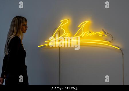 London, Großbritannien. 15. April 2024. Ein Mitarbeiter mit „Be Brave“, 2014, von Tracey Emin (Est. £30.000 - 50.000) bei einer Vorschau auf Phillips „New Now“-Verkauf zeitgenössischer Kunst. Die Lose werden am 19. April in den Galerien des Berkeley Square von Phillips versteigert. Quelle: Stephen Chung / Alamy Live News Stockfoto
