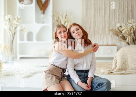 Zwei Erwachsene Schwestern sitzen in einer Umarmung. Weibliche Freundschaft, Familie Stockfoto