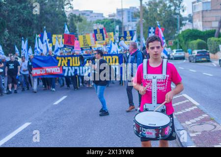 Haifa, Israel - 13. April 2024: Menschen nehmen an einem protestmarsch mit verschiedenen Zeichen und Flaggen gegen die Regierung Teil und rufen zu Neuwahlen auf. Stockfoto