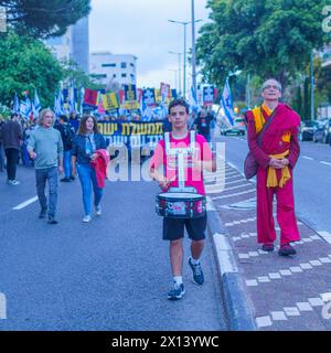 Haifa, Israel - 13. April 2024: Menschen nehmen an einem protestmarsch mit verschiedenen Zeichen und Flaggen gegen die Regierung Teil und rufen zu Neuwahlen auf. Stockfoto