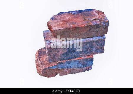 Stapel alter roter Steine isoliert auf weißem Hintergrund in Nahaufnahme. Stockfoto
