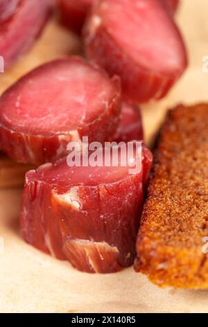 Getrocknetes Naturfleisch mit Gewürzen, weiches gesalzenes Fleisch auf dem Tisch Stockfoto