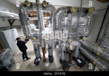 Meldorf, Deutschland. April 2024. Ein Medienvertreter filmt im Kesselraum des ersten unterirdischen Lagers in Deutschland. Nach dem Beispiel Dänemarks sollen öffentliche Gebäude und Haushalte in Meldorf künftig beheizt und mit Fernwärme und gespeicherter industrieller Abwärme sowie Solarenergie versorgt werden. Quelle: Marcus Brandt/dpa/Alamy Live News Stockfoto