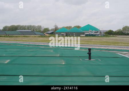 Meldorf, Deutschland. April 2024. Blick vom ersten unterirdischen Speicher Deutschlands auf eine Biogasanlage. Nach dem Beispiel Dänemarks sollen öffentliche Gebäude und Haushalte in Meldorf künftig beheizt und mit Fernwärme und gespeicherter industrieller Abwärme sowie Solarenergie versorgt werden. Quelle: Marcus Brandt/dpa/Alamy Live News Stockfoto