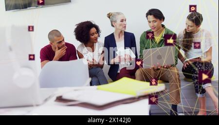 Bild von vernetzten Computersymbolen, die einen Globus über verschiedenen Männern bilden und Kollegen das Projekt erklären Stockfoto