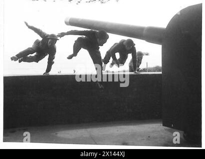 Die Schützencrew an Bord der HMS Hood springt über die Attika, um ihre Waffe zu bemannen, nachdem sie während einer Übung ein „Alarmsignal“ gegeben hat, was die Bereitschaft und die Marineprozeduren in der britischen Armee demonstrierte. Stockfoto