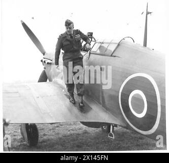 Kommandanten der Armee und der Luftwaffe beobachten eine Demonstration der Airborne Division, bei der Air Marshal Sir A. Barratt vor dem Verlassen des Flugzeugs vom Flughelm auf den RAF-Hut wechselt. Stockfoto