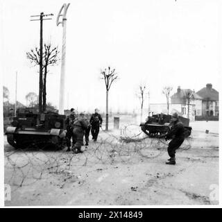 KRIEGSKORRESPONDENTEN BESUCHEN DAS ÖSTLICHE KOMMANDO - ein „feindliches“ gepanzertes Fahrzeug, das in Stacheldraht der britischen Armee verwickelt ist Stockfoto