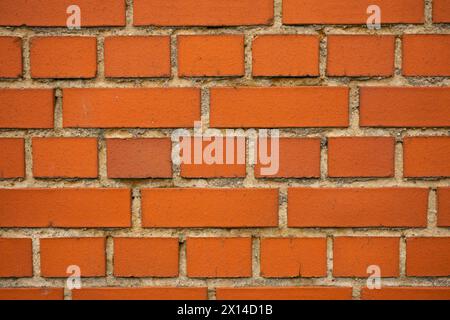 Eine rote Ziegelmauer bei Tageslicht und ein bewölkter Himmel. Stockfoto