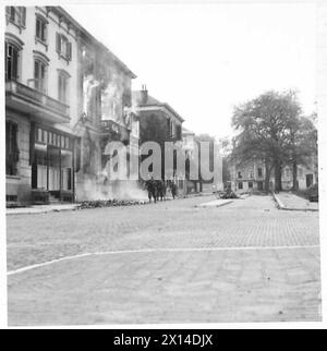 STRASSENKÄMPFE IN ARNHEIM - britische Truppen, die durch die Straßen der Stadt spazieren, passieren viele brennende Gebäude, British Army, 21st Army Group Stockfoto