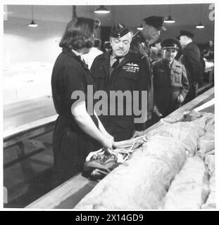 Kommandanten der Armee und der Luftwaffe beobachten eine Demonstration der Airborne Division, bei der Air Marshal Sir A. Barratt mit einem WAAF-Fallschirmpacker im Packraum spricht. Stockfoto