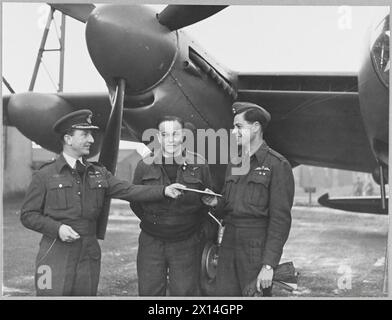 R.A.F. MOSQUITO's REKORDFLUG NACH INDIEN - Foto aufgenommen zu Beginn des Fluges eines Mosquito-Flugzeugs der RAF Transport Command nach Indien. Der bisher schnellste Flug zwischen den beiden Ländern dauerte 14 Stunden und 37 Minuten Flugzeit. SIEHE A.M.BULLETIN NR. 16295. Das Bild (ausgestellt 1944) zeigt: Gruppenkapitäne M. D. Chichton - Biggie, DFC., der Offizier, der die RAF-Station kommandiert, von der aus der Flug durchgeführt wurde, und übergibt dem Piloten - Flight Leutnant J.B. Linton, den Apacket der neuesten Fotografien, die über Europa aufgenommen wurden, für den Transport nach Indien. In der Mitte befindet sich der Navigator - Haftbefehler E.J. Goudie Roya Stockfoto