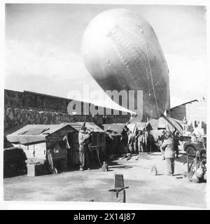 FÜNFTE ARMEE: ANZIO BRÜCKENKOPF 'BESSER 'OLES' AUF DEM ANZIO BRÜCKENKOPF - 'Millionaire's Row' acht Hütten auf dem Maulwurf. Vom „Vorgarten“ aus wird ein Staudamm-Ballon gestartet. Alle diese Hütten wurden von der amerikanischen Besatzung einer Bofors-Kanone gebaut. Sie leben am Ende des Maulwurfs, in der Nähe ihrer Kanone, eine Position, die bei schlechtem Wetter sowohl kalt als auch nass werden kann Stockfoto