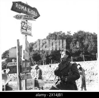 ITALIEN: FÜNFTE ARMEE: ANZIO BRIDGEHEADPTE. JOHNSON - VERSTÄRKUNG DER QUEENS - Johnson hält an einem Wegweiser "Roma km 58.6" British Army Stockfoto