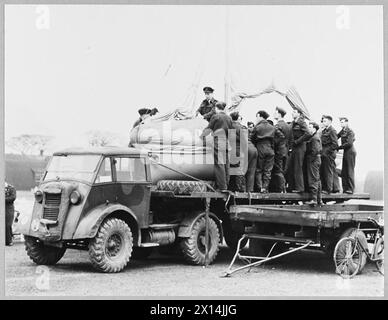 „AIRBORNE LIFE BOAT“ WURDE FLUGBESATZUNGEN VORGEFÜHRT – „The Boat on the Float“ wird auf den Flugplätzen des Bomber Command zu einem vertrauten Anblick. Dieses seltsame Schiff ist das Rettungsboot, das neueste Gerät zur Rettung von Fliegern, die gezwungen sind, im Meer zu graben. Auf einem LKW montiert, wird es auf eine Tour durch die Bomber Squadron gebracht, damit die Männer, die es benutzen müssen, damit vertraut sind und wissen, wie man damit umgehen muss. Ein Experte für Luft- und Seerechtsysteme demonstriert, wie die Segel aufgerüstet und der kleine Motor handhabt. Das Rettungsboot wird an die Stelle geflogen, an der die Flieger herumfliegen. Es ist am Bauch des Flugzeugs l befestigt Stockfoto