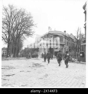 STRASSENKÄMPFE IN ARNHEIM - britische Truppen, die durch die Straßen der Stadt spazieren, passieren viele brennende Gebäude, British Army, 21st Army Group Stockfoto