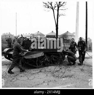 KRIEGSKORRESPONDENTEN BESUCHEN DAS ÖSTLICHE KOMMANDO - ein „feindliches“ gepanzertes Fahrzeug, das in Stacheldraht der britischen Armee verwickelt ist Stockfoto