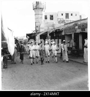 FÜHRUNG DURCH HRH EL EMIR MANSUR IBN SAUD - einige der britischen Seeleute des Marineskortes mit ihrem Reiseleiter in einer der Hauptstraßen von Dschidda Stockfoto